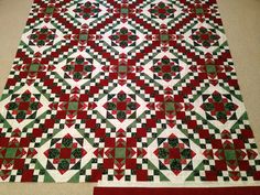 a red and green quilt is laying on the floor