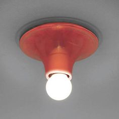 a light that is on the ceiling in a room with gray walls and flooring