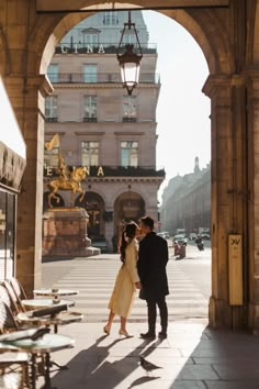 a man and woman are standing under an archway