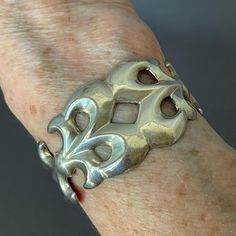 Gorgeous, heavy (42 grams!) sandcast sterling cuff bracelet,   Native American made around the 1970s. Beautiful fluid scroll design with sort of a fleur de lis motif. Typical cuff bracelet of the Southwest of the time. Diameter at widest point is 2" but it can be stretched to make larger or smaller. The "length" measurement above is inside from end to end. This is a lovely piece of Native American art is a treasure to pass down. Great piece. Length Measurement, Scroll Design, Native American Art, American Made, American Art, Cuff Bracelet, Native American, Cuff Bracelets, Jewelry Bracelets