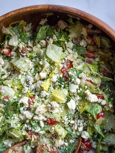 a salad in a bowl with wooden spoons on the side, ready to be eaten