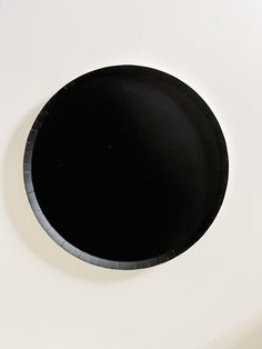 a black plate sitting on top of a white table