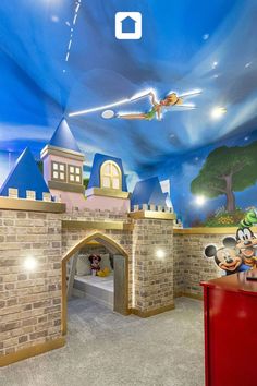 a child's bedroom with a castle theme painted on the ceiling and walls, along with mickey mouse toys