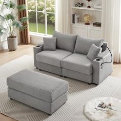 a living room scene with focus on the couch and ottoman