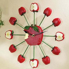 a clock made out of apples and cherries is on the wall next to a table