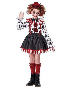 a woman dressed as a clown with red hair and black boots, wearing a costume