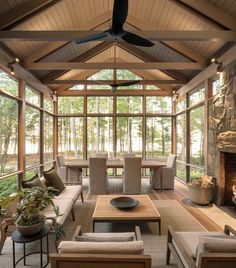 a living room filled with lots of furniture and a fire place under a ceiling fan