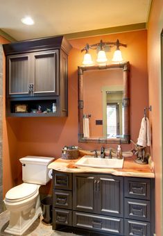 a bathroom with a toilet, sink and mirror in it's center piece is shown