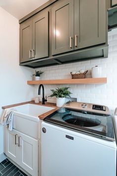 a washer and dryer sitting in a kitchen next to cabinets on the wall