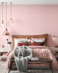 a bedroom with pink walls and furniture in the corner, along with a large bed