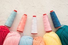 four balls of yarn are lined up next to each other in different colors and sizes