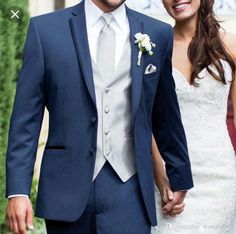 a man and woman in wedding attire holding hands while standing next to eachother