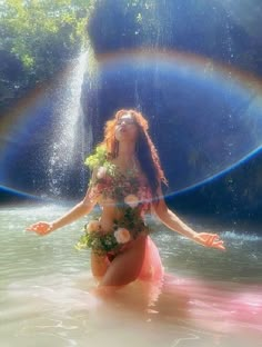 a woman is in the water with her arms spread out and flowers on her chest