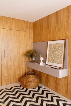 a room with wood paneling and black and white rugs on the floor next to a shelf