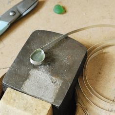 a pair of scissors sitting on top of a block of wood next to some wire