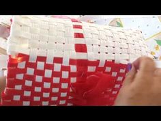 a person is wrapping a red and white basket