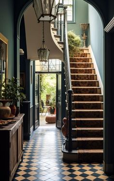 an entry way with stairs leading up to the second floor and potted plants on either side