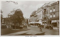 an old black and white photo of people riding bikes on the street in front of buildings