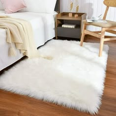 a white sheepskin rug is on the floor next to a bed and nightstands