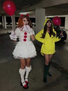 two women dressed in costumes standing next to each other with balloons on their heads and one holding a red balloon