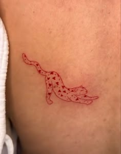 a cat tattoo on the back of a woman's stomach, with red ink