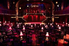 an empty stage with lots of tables and chairs