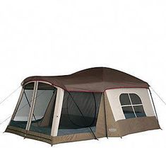 a tent that is set up on the ground with its door open and windows closed