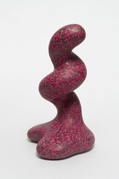 a pink and black sculpture sitting on top of a white table