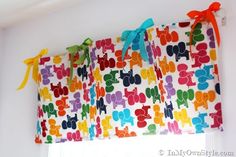 the curtain is decorated with colorful letters and bows on it's rodo - tie