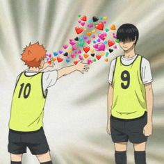 two young men in soccer uniforms with hearts coming out of their backs and hands to each other