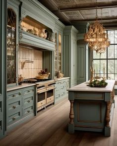 a kitchen with green cabinets and chandelier hanging from the ceiling, along with wooden flooring