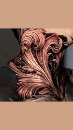 an artistic tattoo design on the back of a man's neck and shoulder is shown