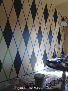 the room is being decorated with black, white and green argyle wallpaper on the walls