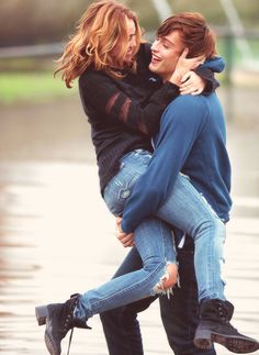 two people are hugging each other in the rain and one person is holding another man