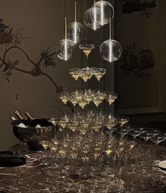 a table topped with lots of wine glasses filled with champagne and hanging from the ceiling