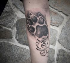 a black and white photo of a paw with the word love written in cursive writing