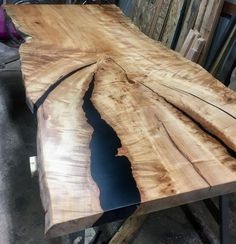 a large wooden table sitting on top of a pile of pallet wood in a shop