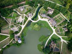 an aerial view of a garden and pond in the middle of a wooded area with lots of trees