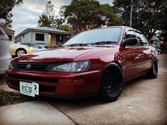 a red car is parked on the street