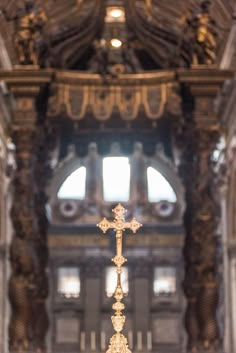 an ornate gold cross in the middle of a church