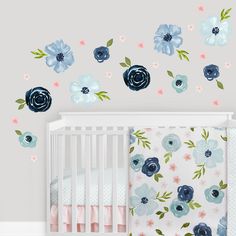 a baby's room with blue and pink flowers on the wall