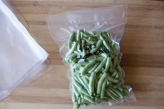 green beans are in a plastic bag on a wooden table