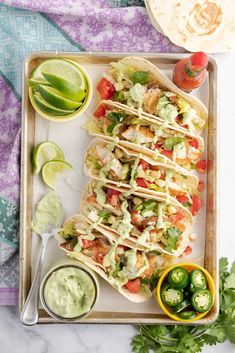 a tray filled with tacos, guacamole and salsa