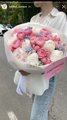 a woman holding a bouquet of flowers on the street