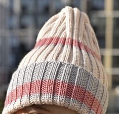 a close up of a person wearing a knitted beanie hat with red, white and blue stripes