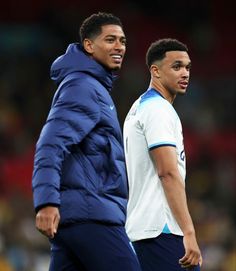 two soccer players standing next to each other