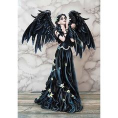 a statue of an angel with black wings