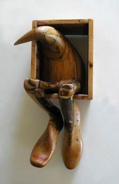 a wooden sculpture of a bird in a box