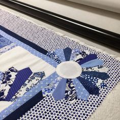 a blue and white quilt is laying on the table