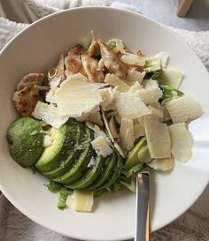 a white bowl filled with lots of different types of food on top of a table